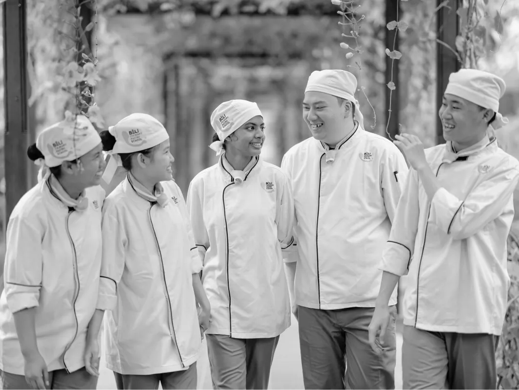 Happy culinary students in chef uniforms