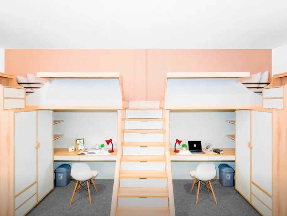 Dormitory room with bunk beds and desks